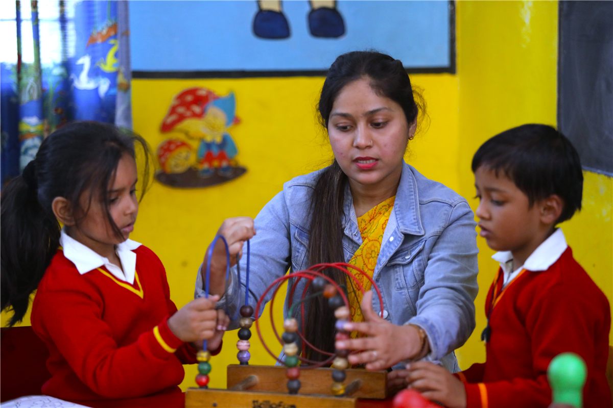 A teacher guiding pre-primary children through a hands-on activity at Scholars' Home Lucknow